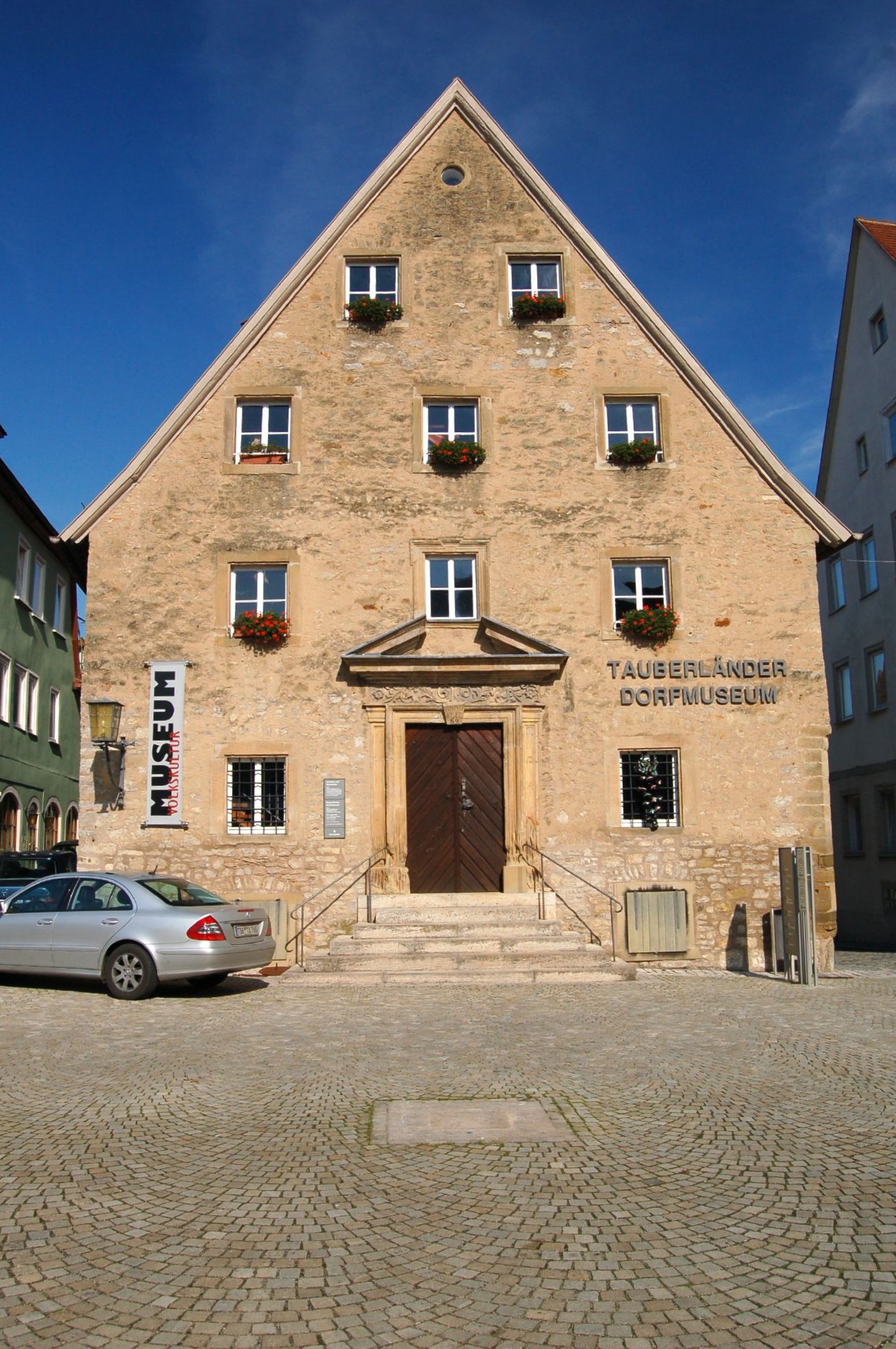 two parked cars are in front of a small building