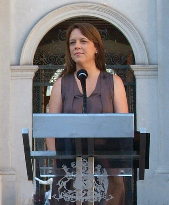 a person at a podium wearing a gray shirt