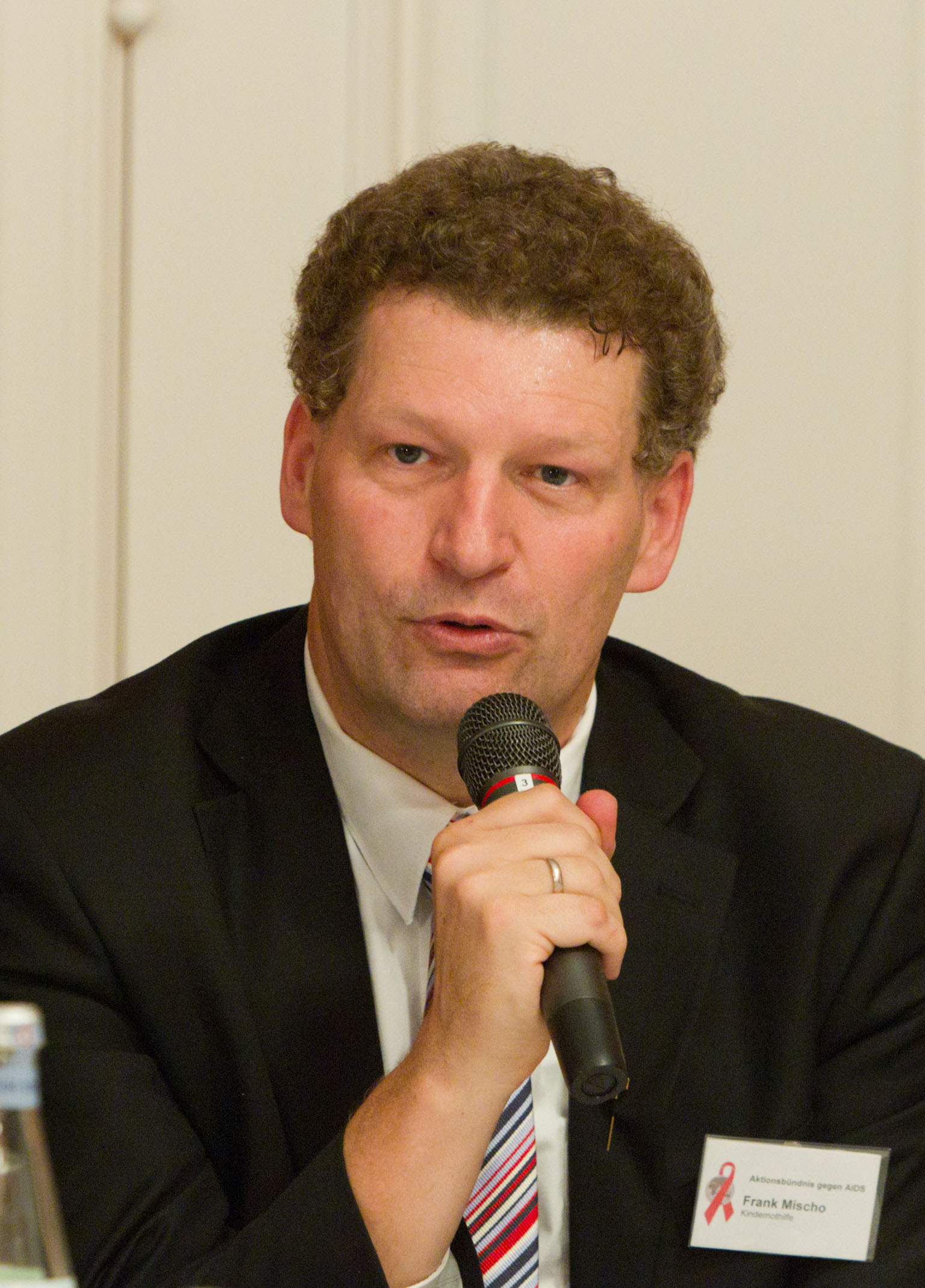 a man holds a microphone while sitting at a table