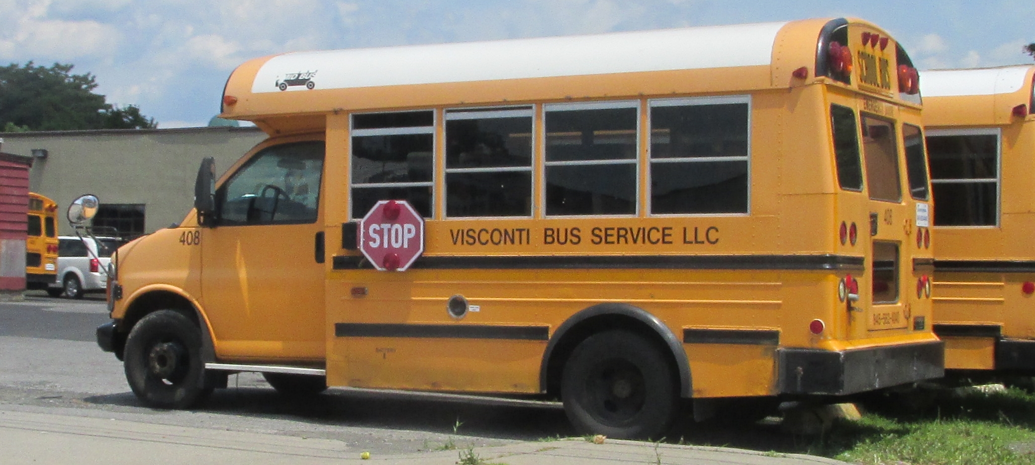 two yellow school buses parked on the side of the street