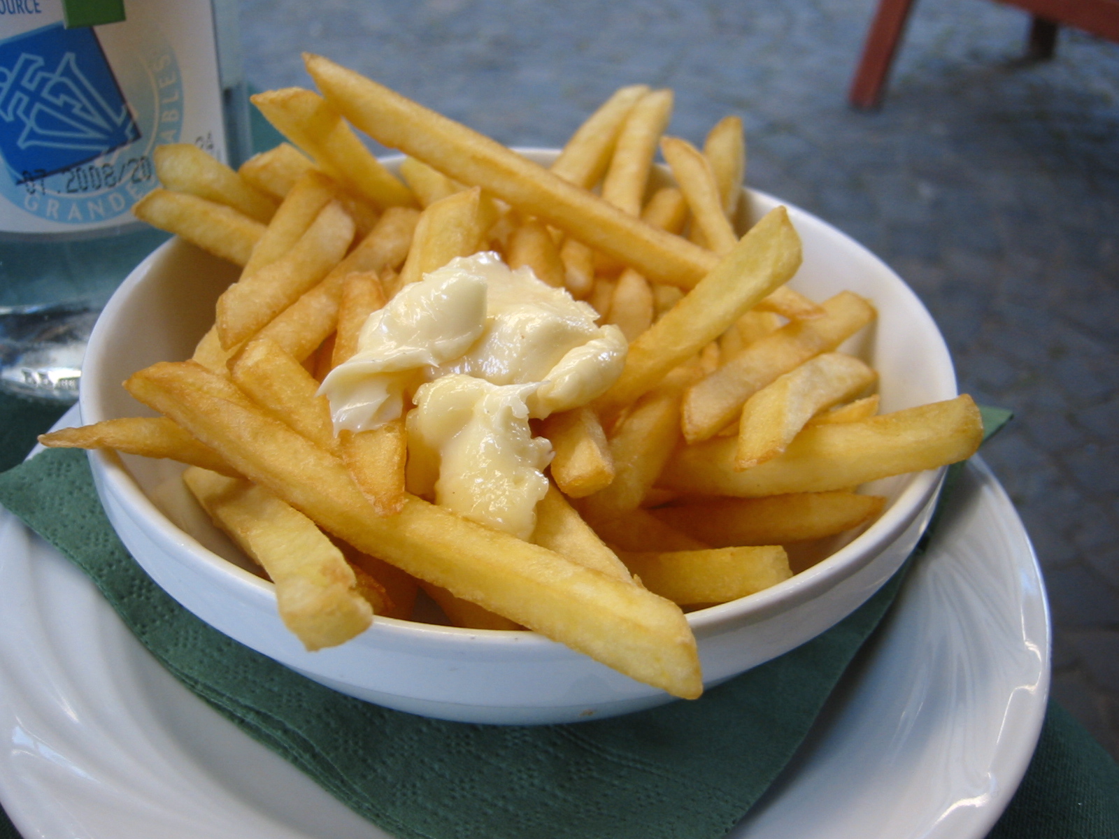 a bowl filled with french fries with white sauce