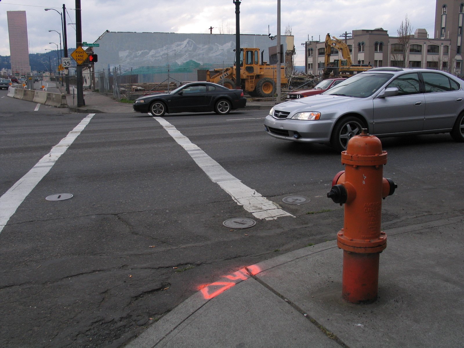 a car is driving away from a red fire hydrant