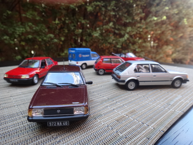 small cars that are on a table in front of trees