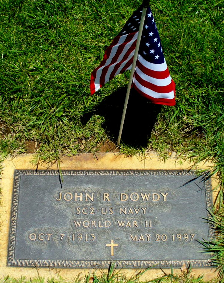 a marker sitting in grass with an american flag at it