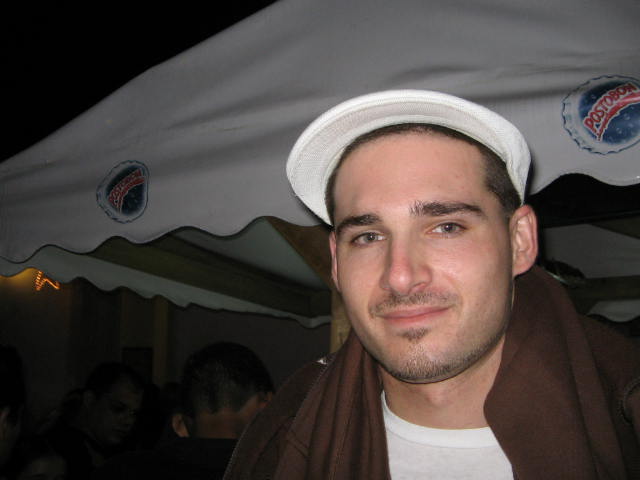 a man with a hat and coat looks at the camera
