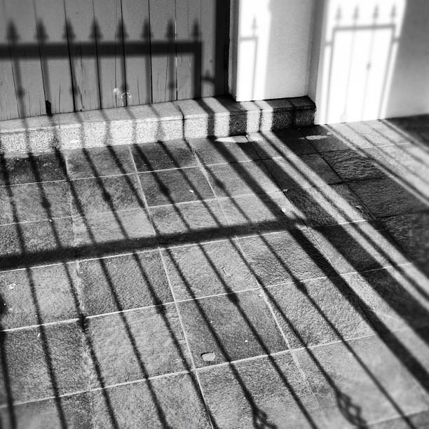 shadows cast by the door on a concrete street