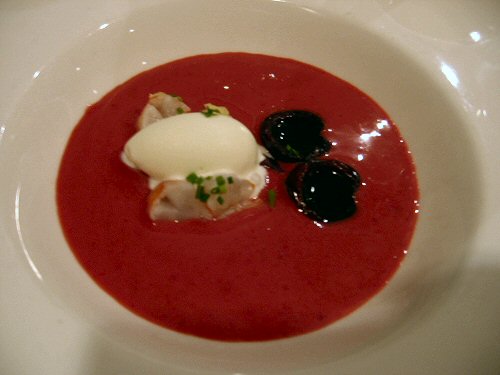 a bowl of soup with cream and garnish