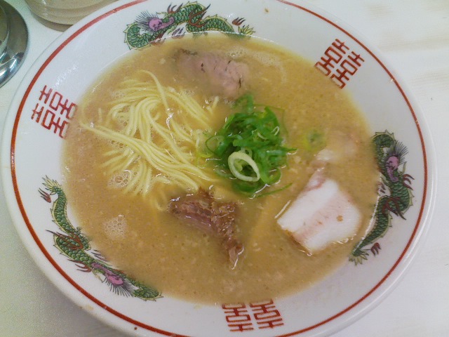 bowl of ramen soup served with chopsticks and onion
