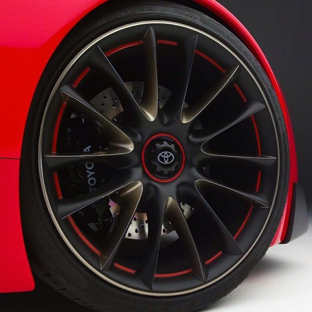 a close up of the rim on a red sports car