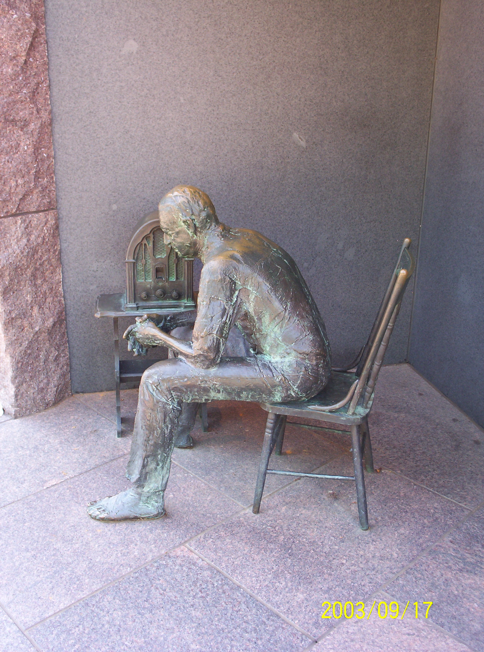 there is a statue that is sitting on a bench