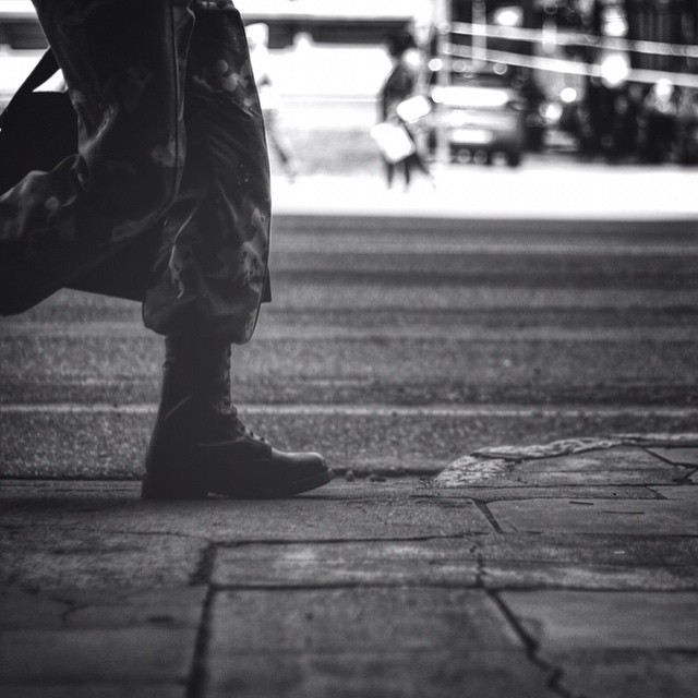 a black and white po of a person standing on a sidewalk