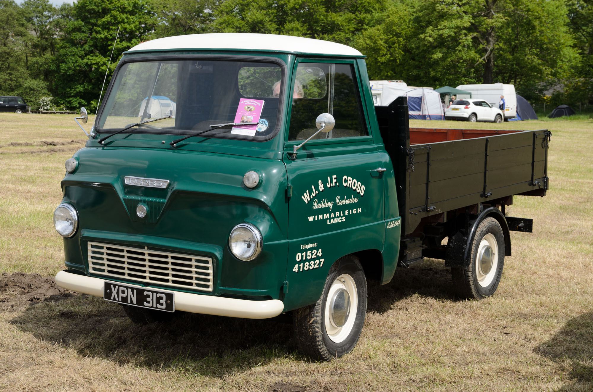 the green truck is parked in a field