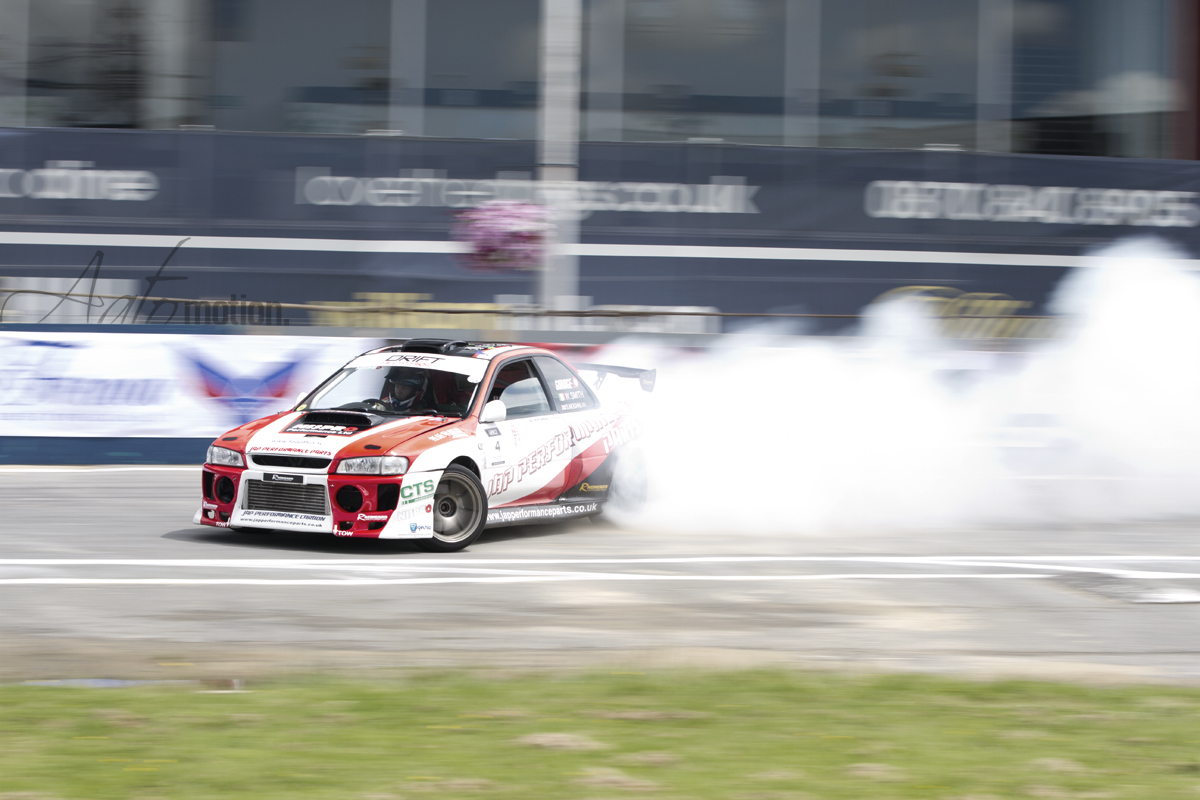 a race car making a burn and rolling around a track