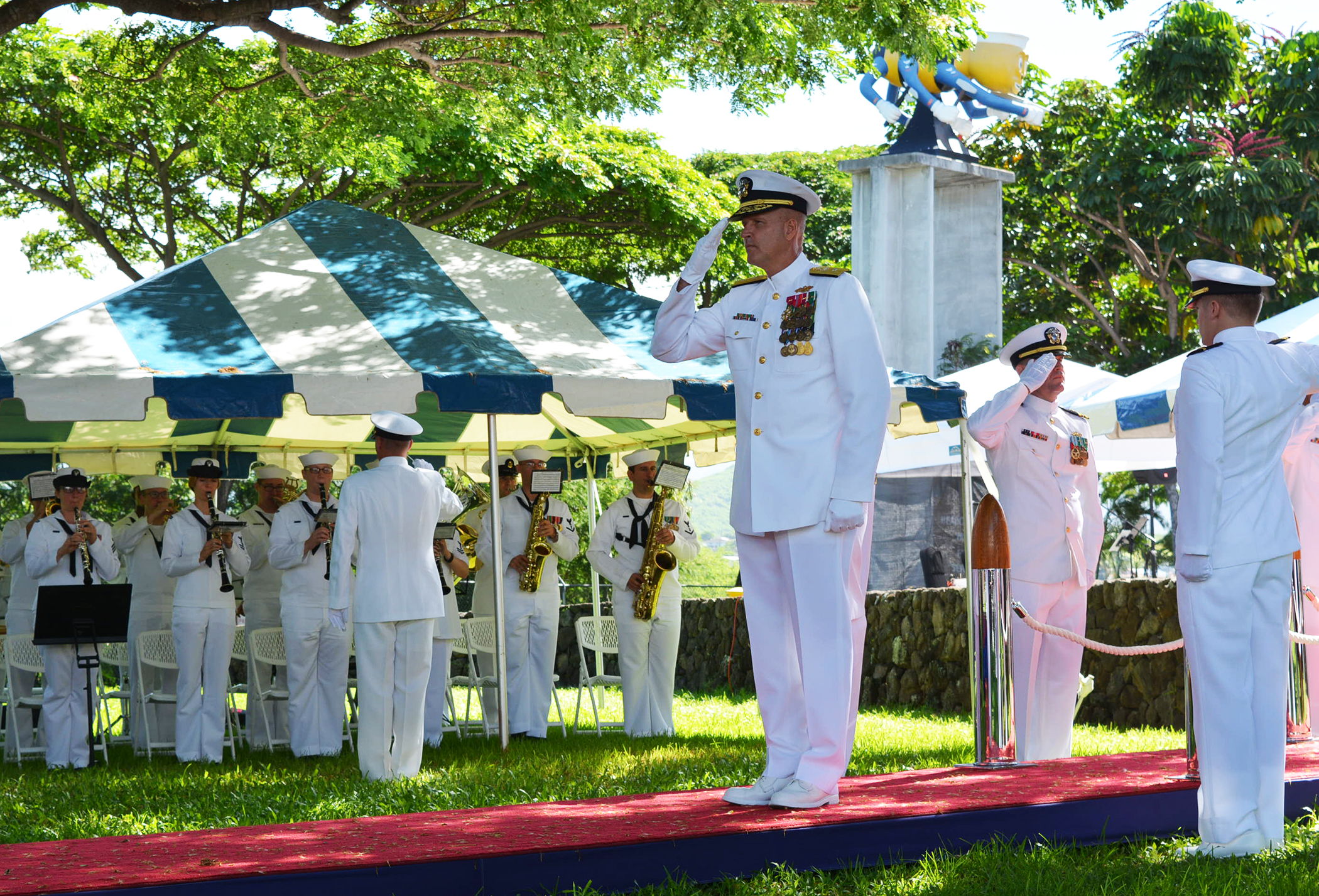 several sailors are standing near each other and a flag is raised in the air