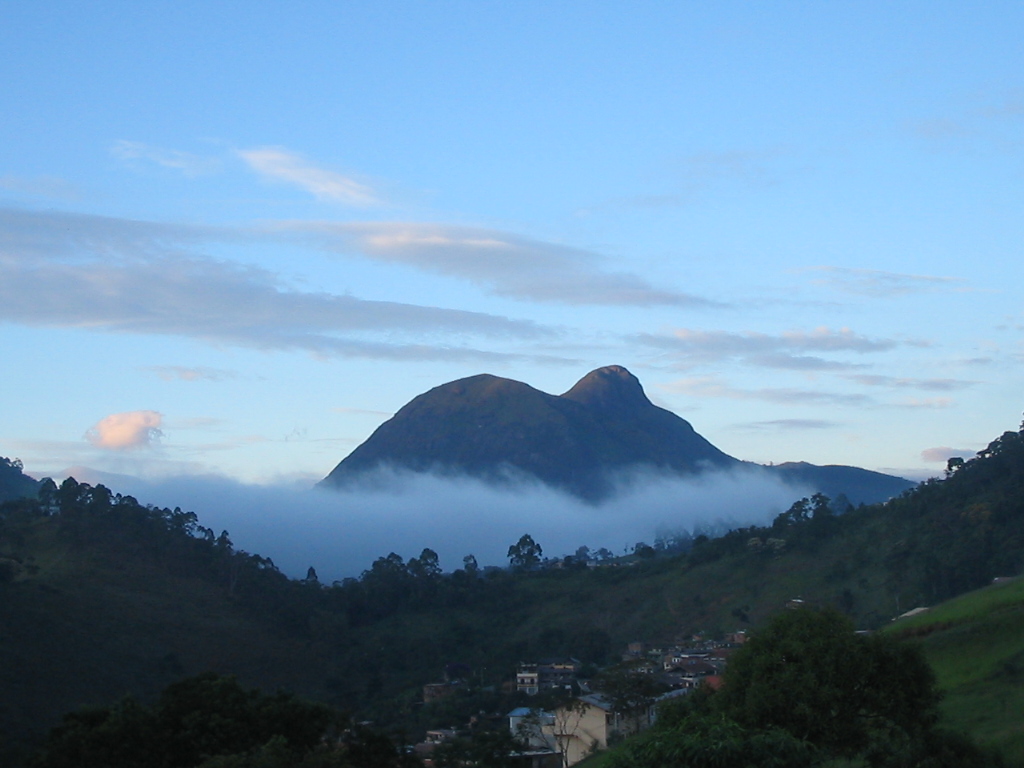 a hill with some clouds behind it