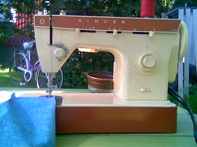 a sewing machine is sitting on a wooden base