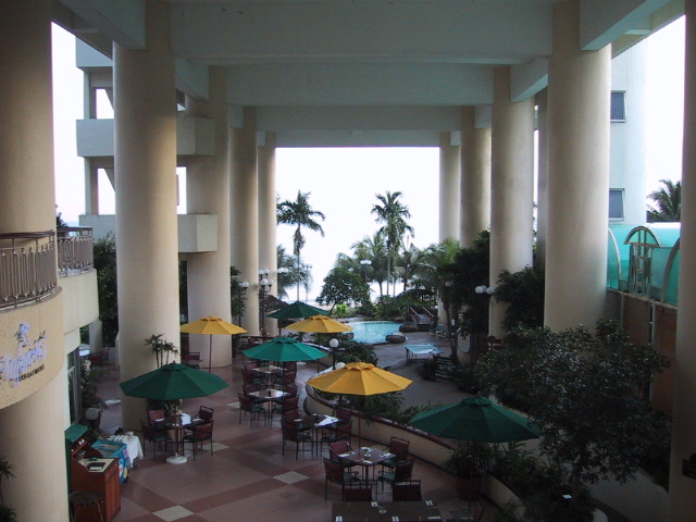 the outside patio of a resort with yellow umbrellas