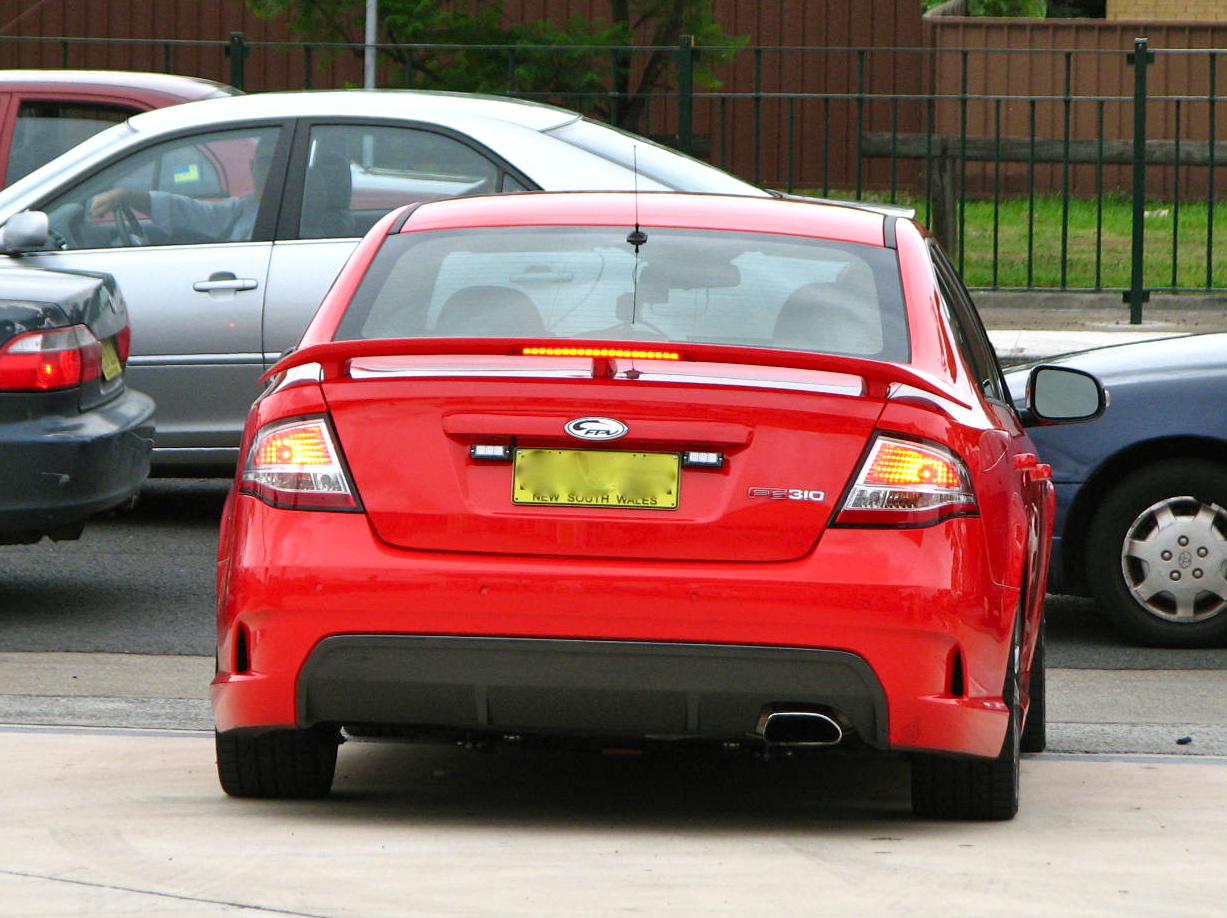 a red car with a yellow tag in the tail end