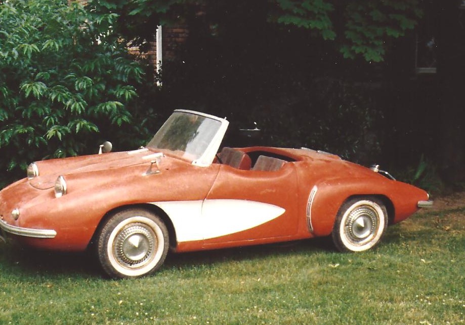 an old fashioned convertible car is sitting in the grass