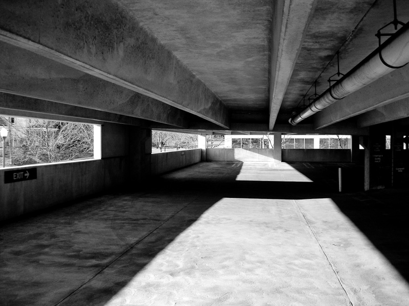 the view inside a tunnel shows two people walking on the sidewalk