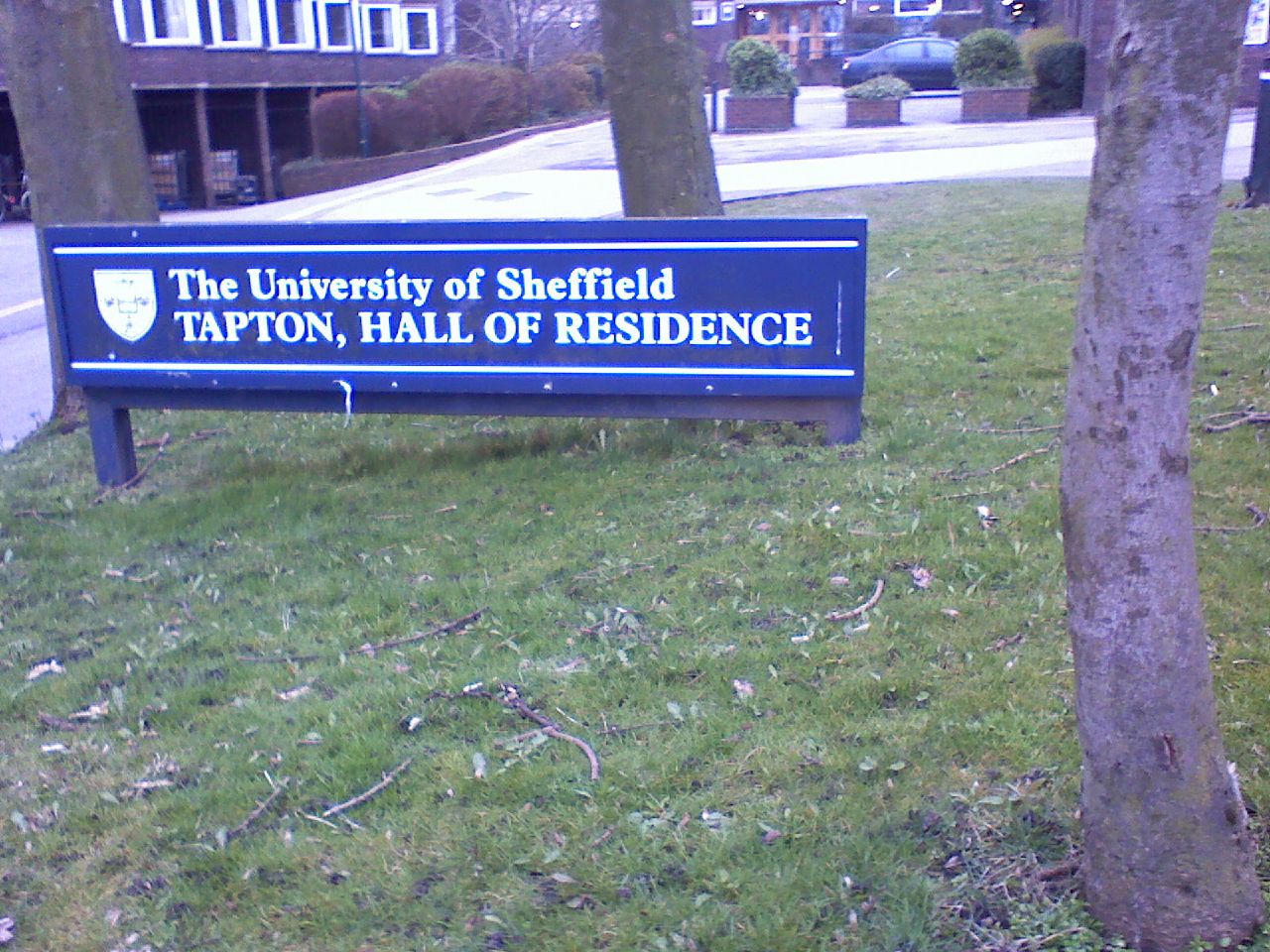 a sign for the university of sheffield in front of a small park