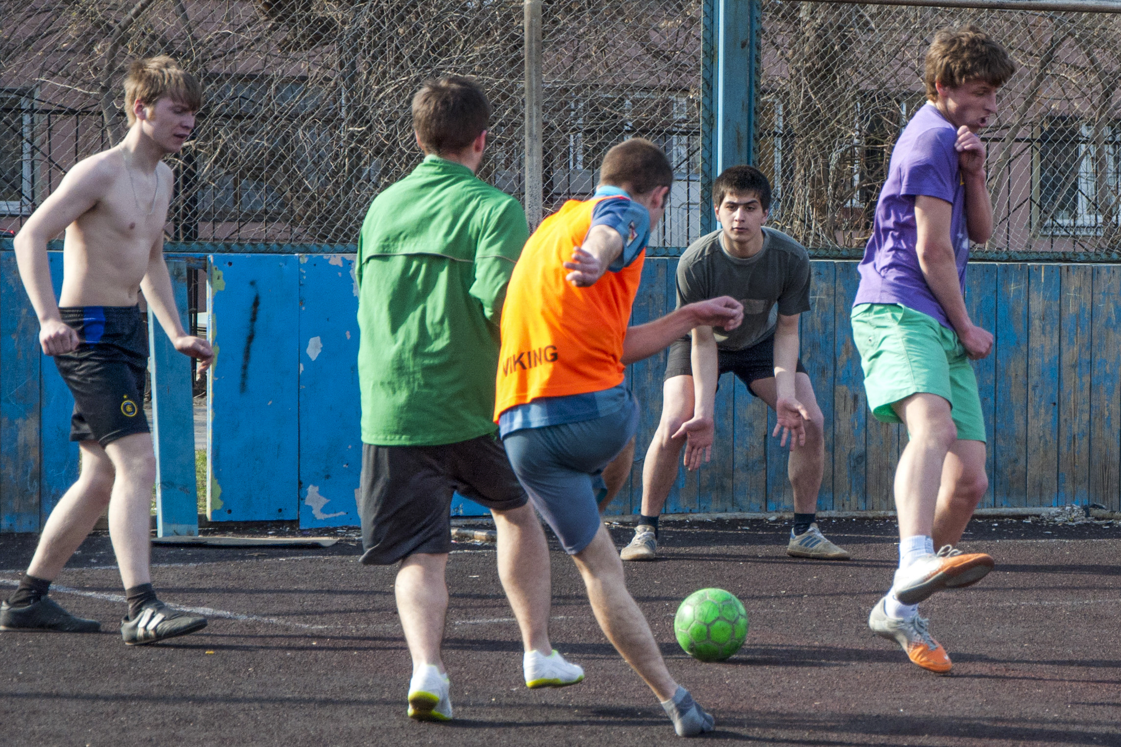 a group of boys play soccer on the court