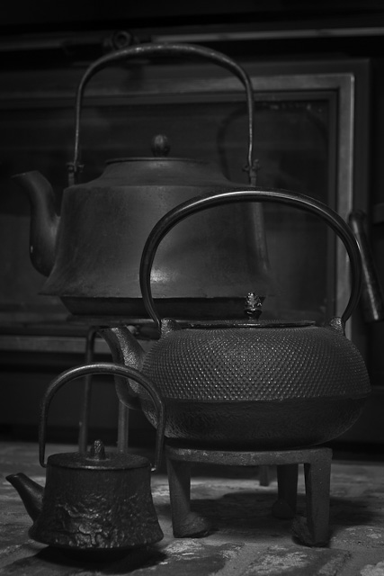 a old kettle sits beside a very metal kettle