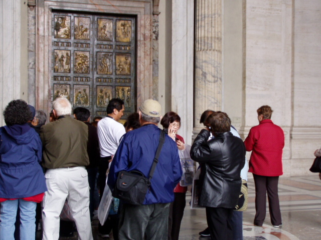 a crowd of people looking in to doors of a building