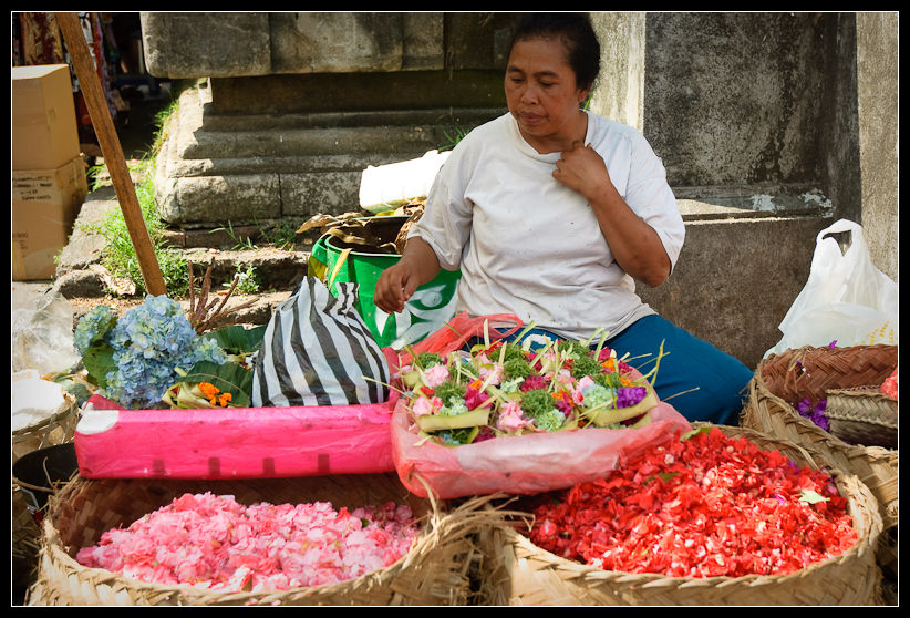 a lady is selling flowers in baskets