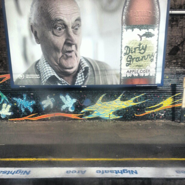 an advertit on the side of a building that has a po of an old man