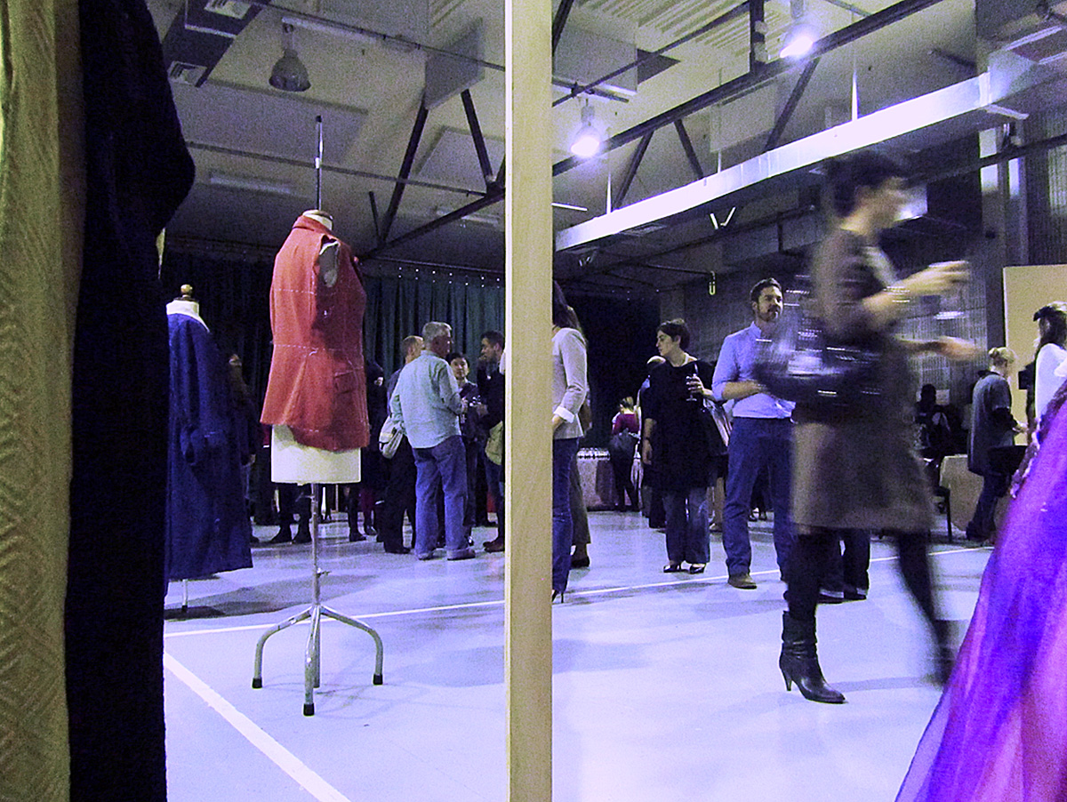 a group of people stand inside a room full of dresses