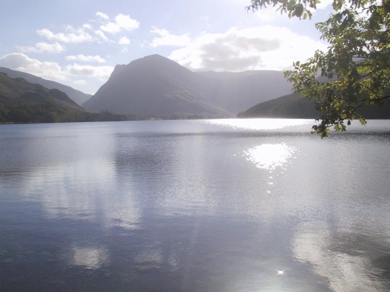 a view of the mountains from the shore of the lake