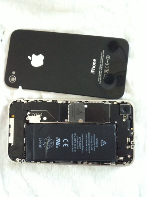the battery of an iphone being dismantled on the table