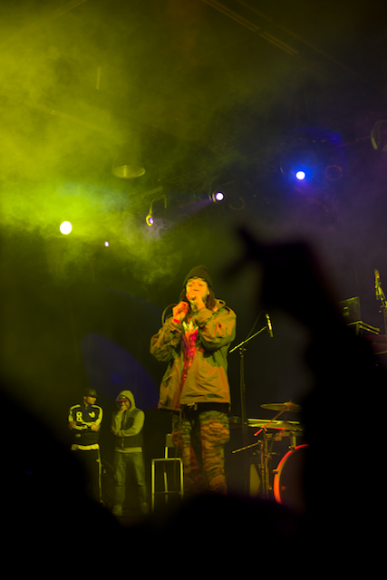 a man singing on stage with colorful lighting behind him