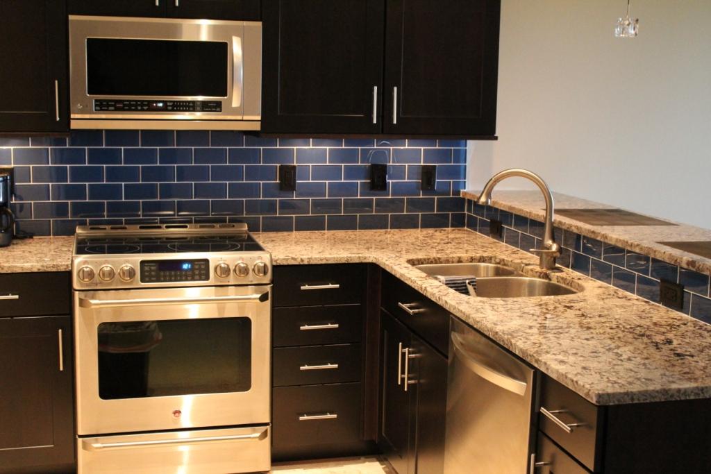 a kitchen with granite counters and stainless steel appliances