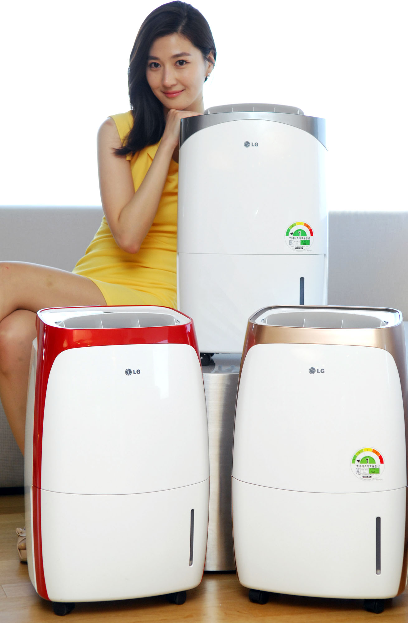a girl sitting on the floor next to a large heater and a smaller one
