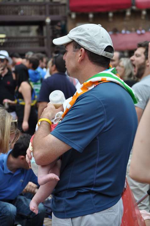 man holding a baby in front of the crowd