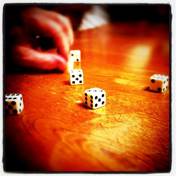dice on the table and one dice is being thrown