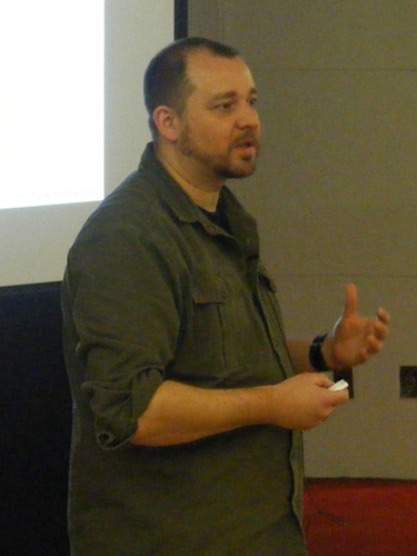 a man speaking to an audience at a seminar