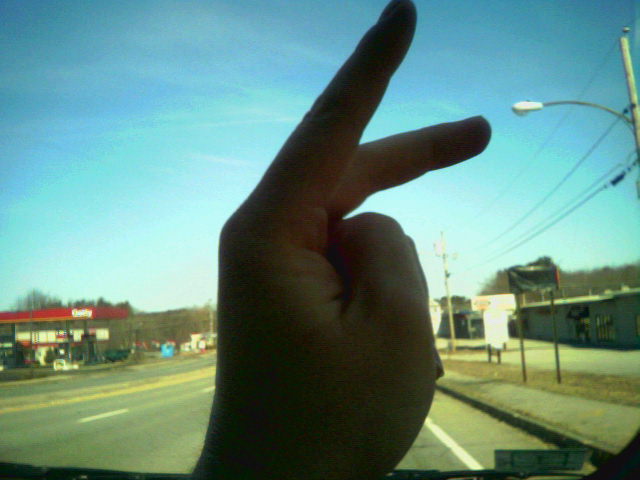 a hand is pointing down at the street