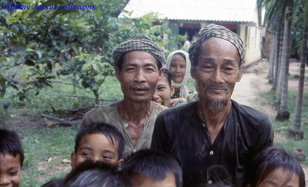 a man is standing between a group of small children