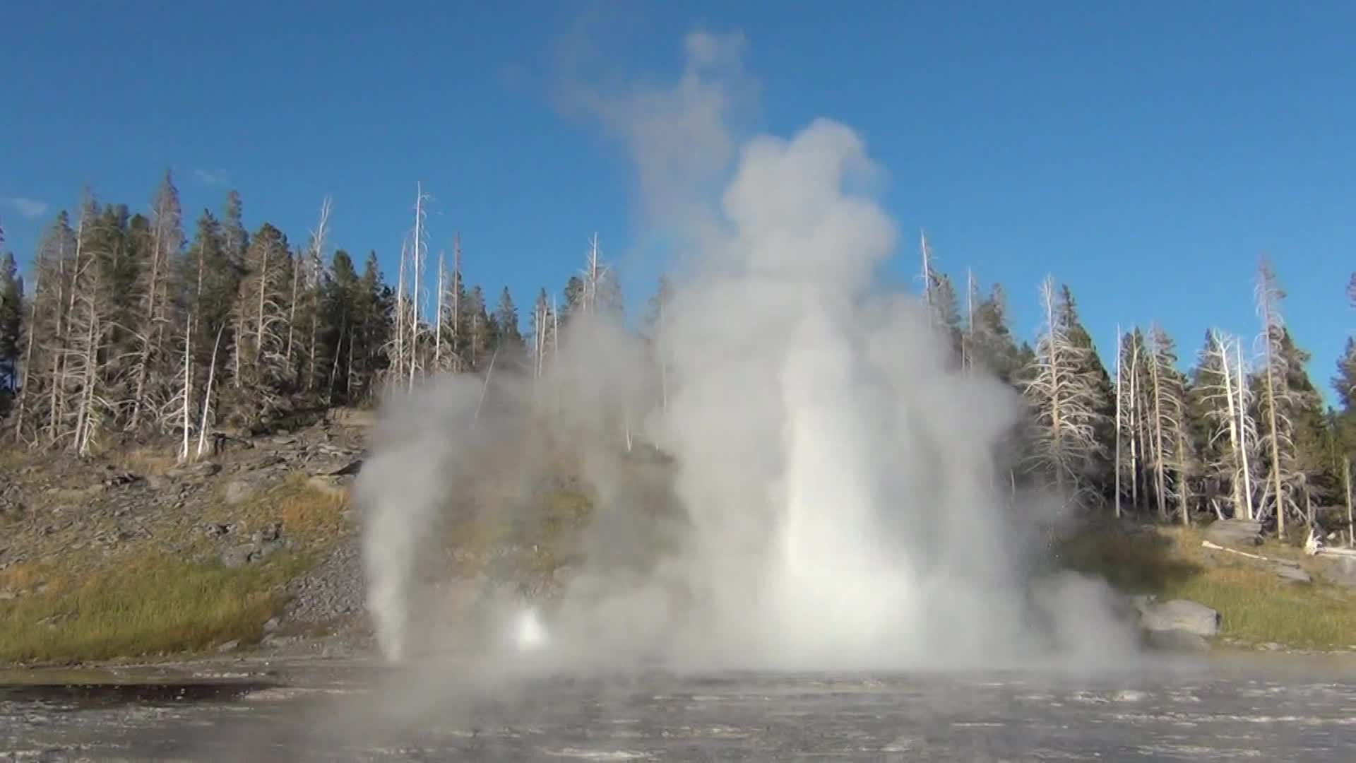 water spraying out from a steam pipe in a pond