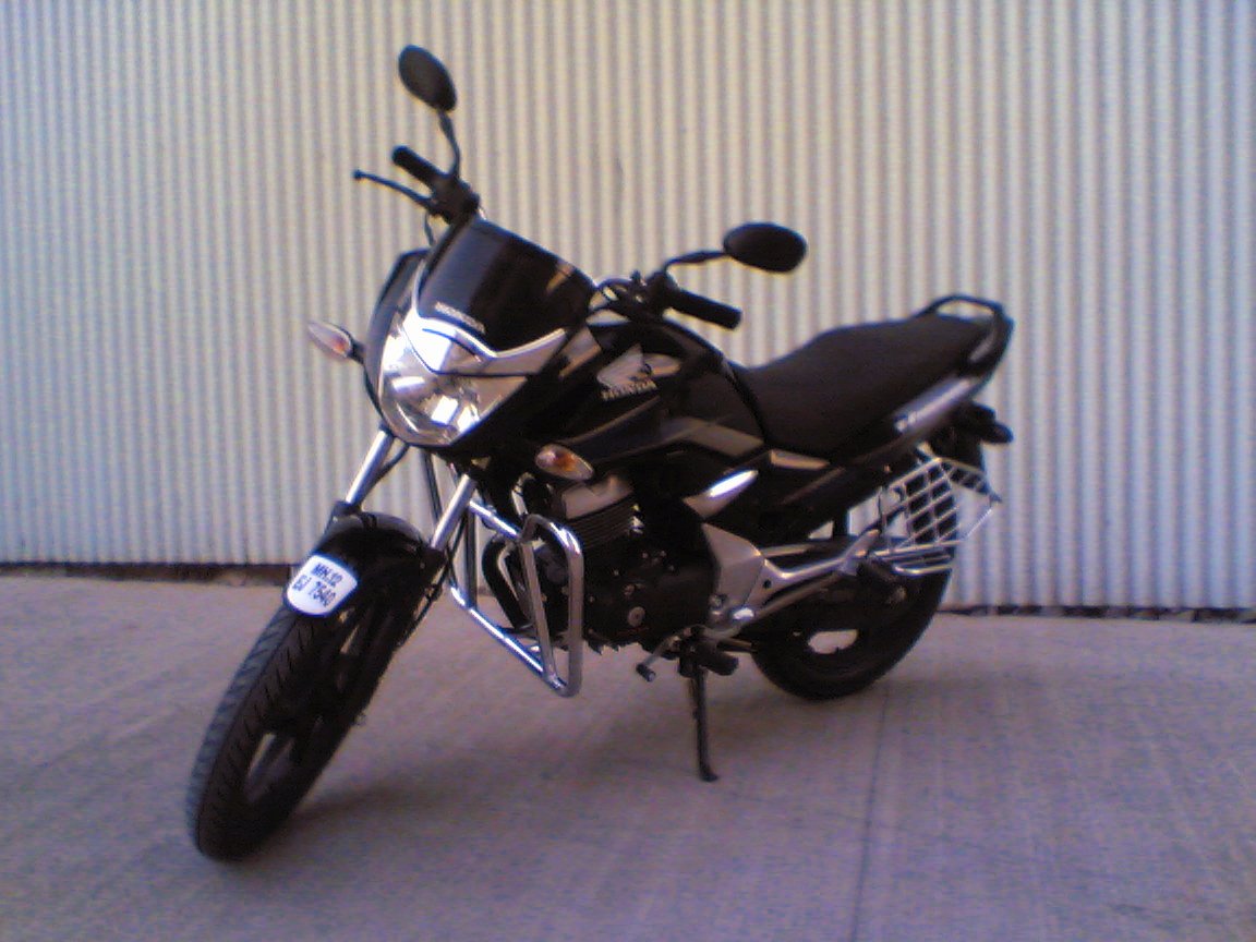 a parked black motorcycle in front of a wall
