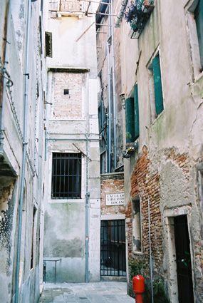a narrow alley way with an open window