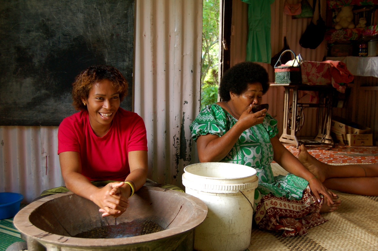 a woman sitting next to a woman with a cell phone