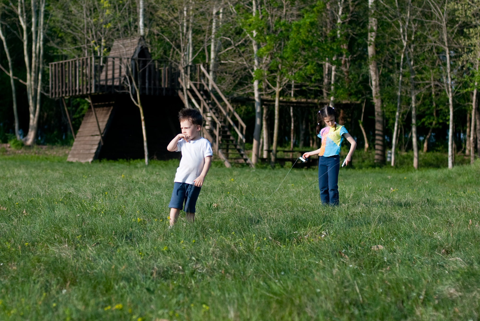 two young children are standing in the grass