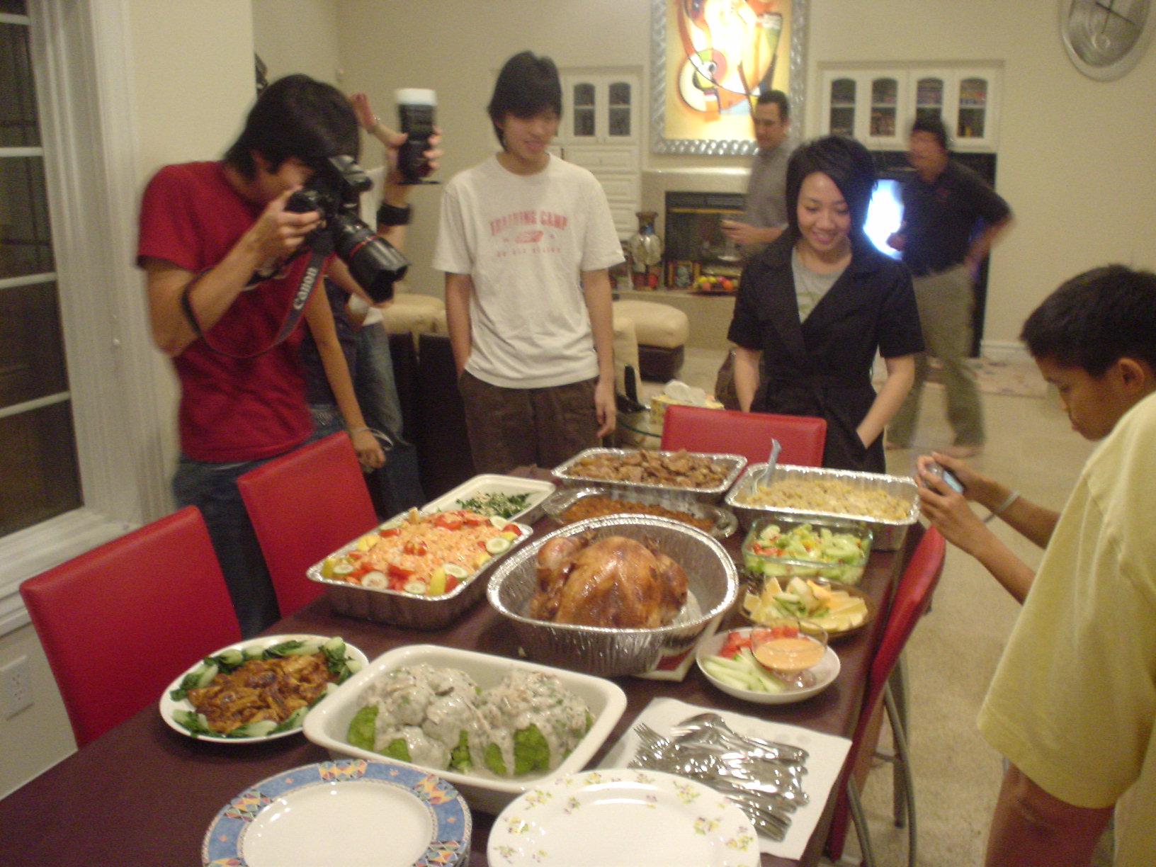 several people surrounding a table covered in plates and pans