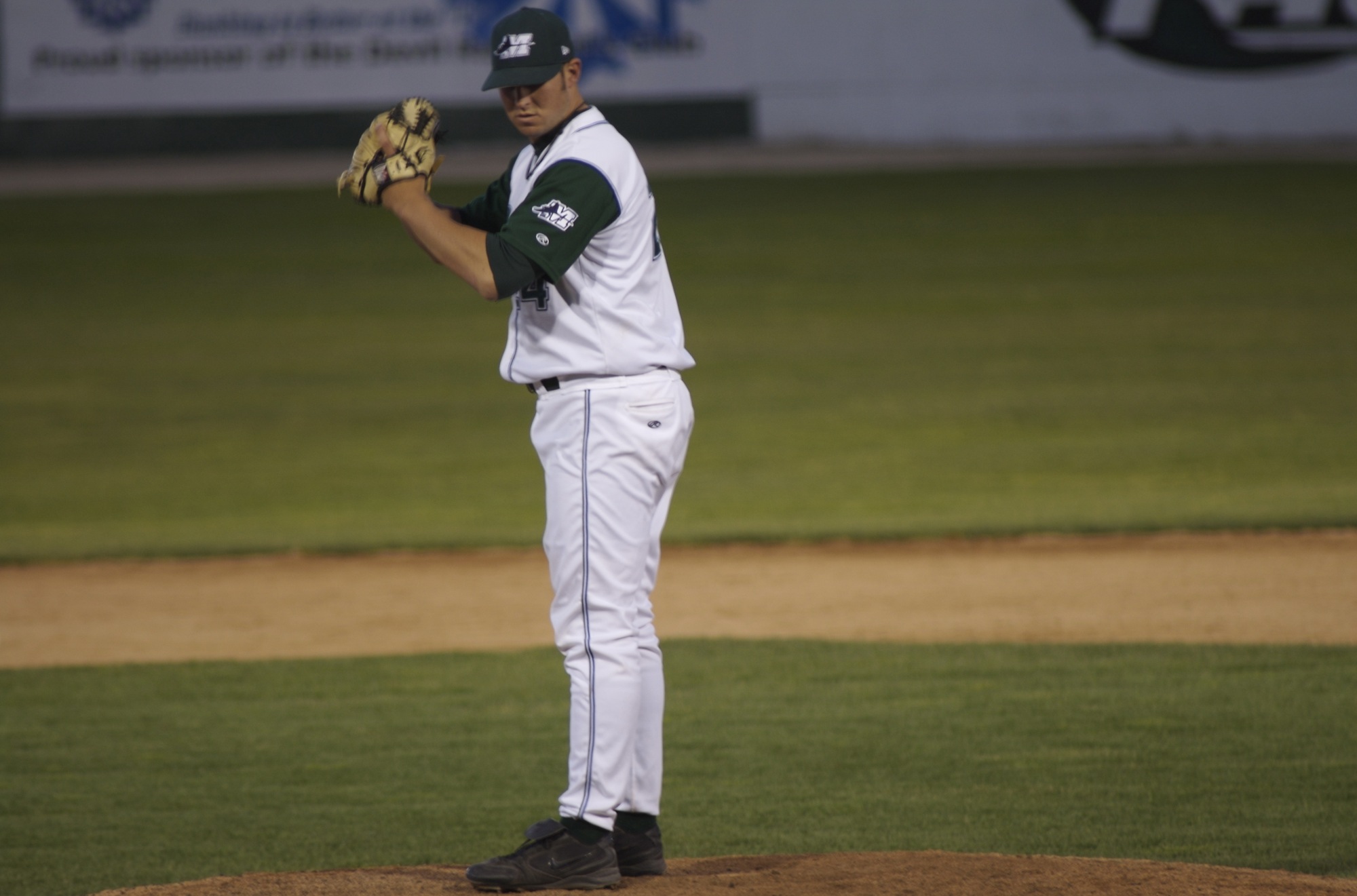 a man is standing on a field while holding a baseball glove