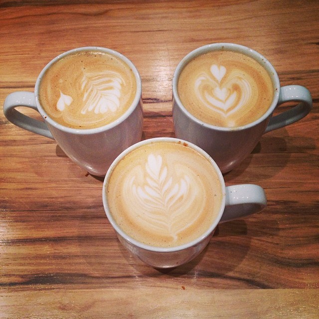 there are three coffee cups with some art in them