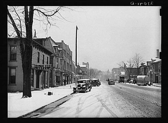 there is a snow covered street and a sign